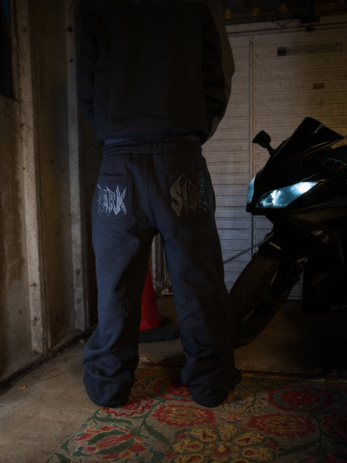 Parkside black joggers — PARK and SIDE pocket embroidery, rear view by the bike