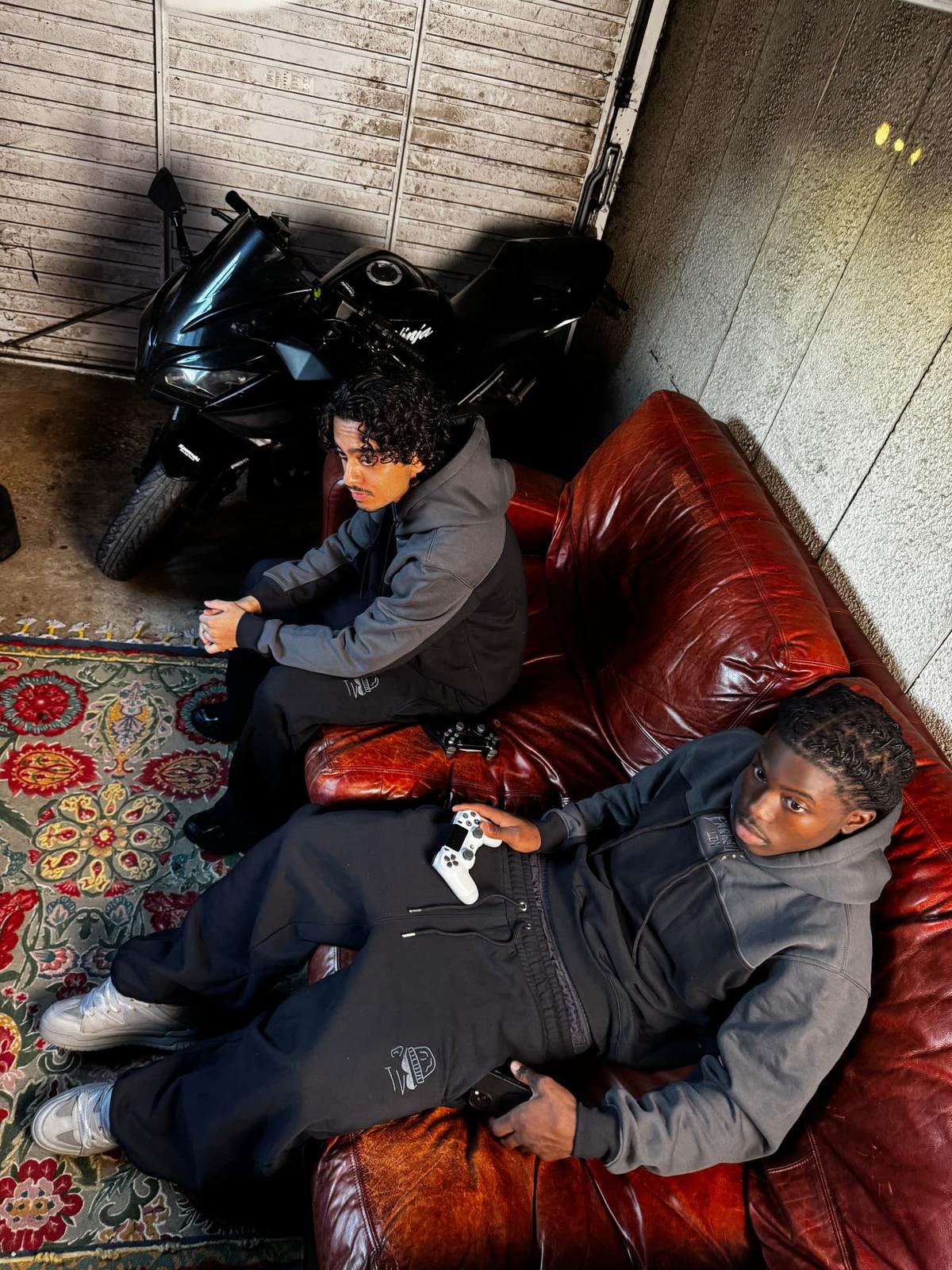 Parkside black tracksuit full set — two models on the sofa