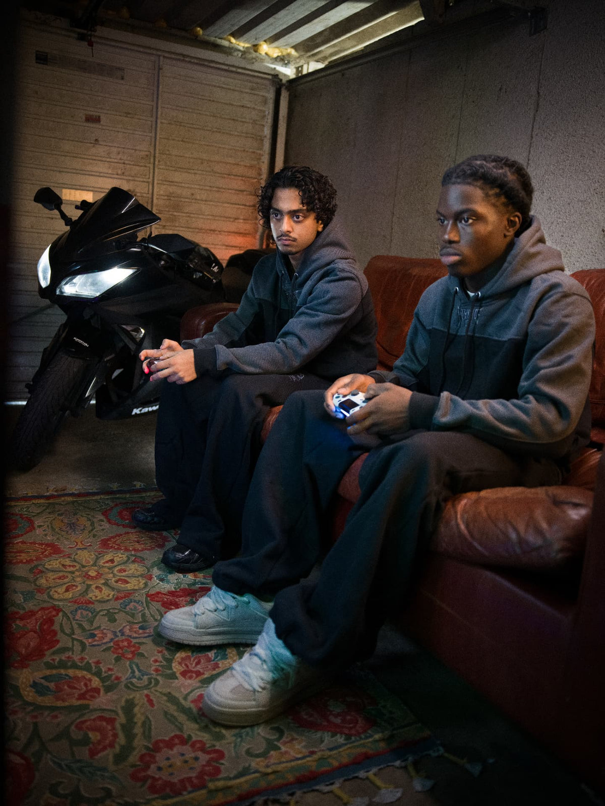 Parkside black tracksuit full set — two models in the full set on the couch by the bike
