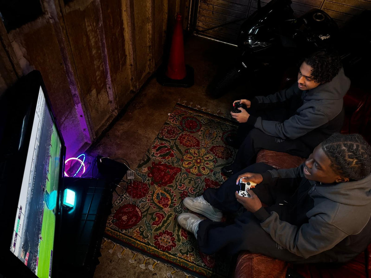 Parkside black hoodie — two models seated gaming