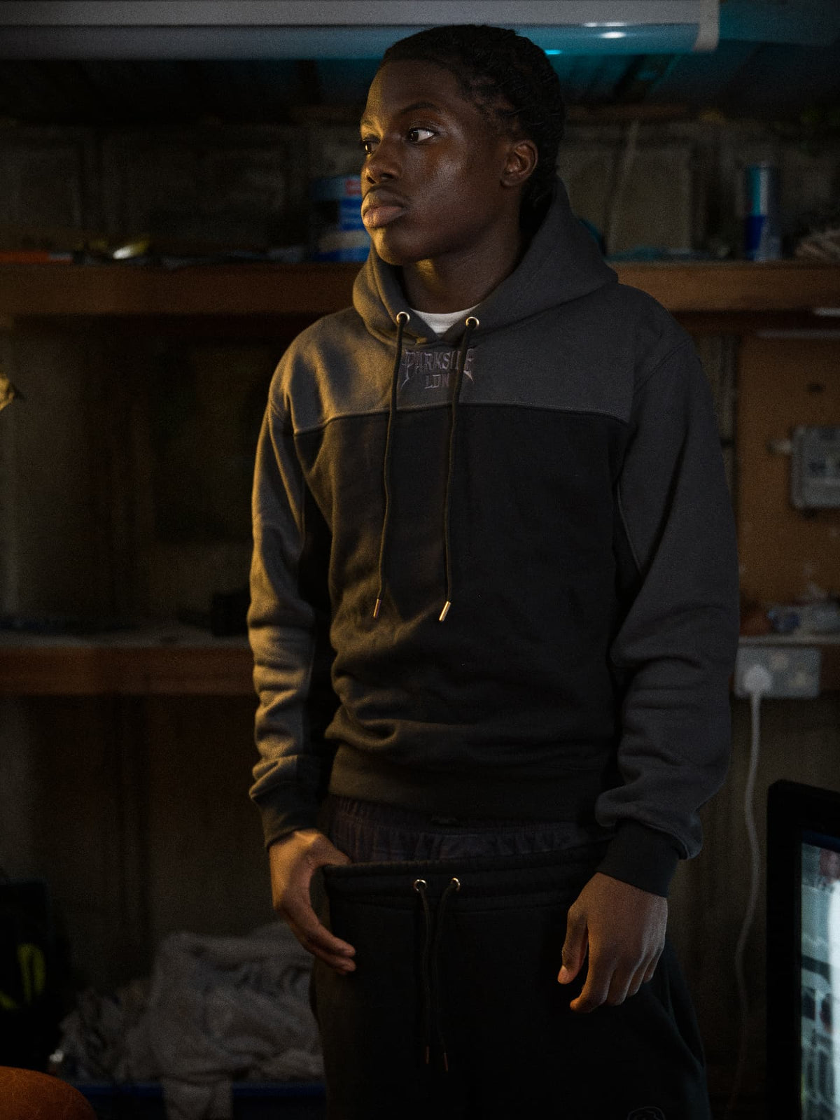 Parkside black hoodie — front chest PARKSIDE LON embroidery, standing in the garage